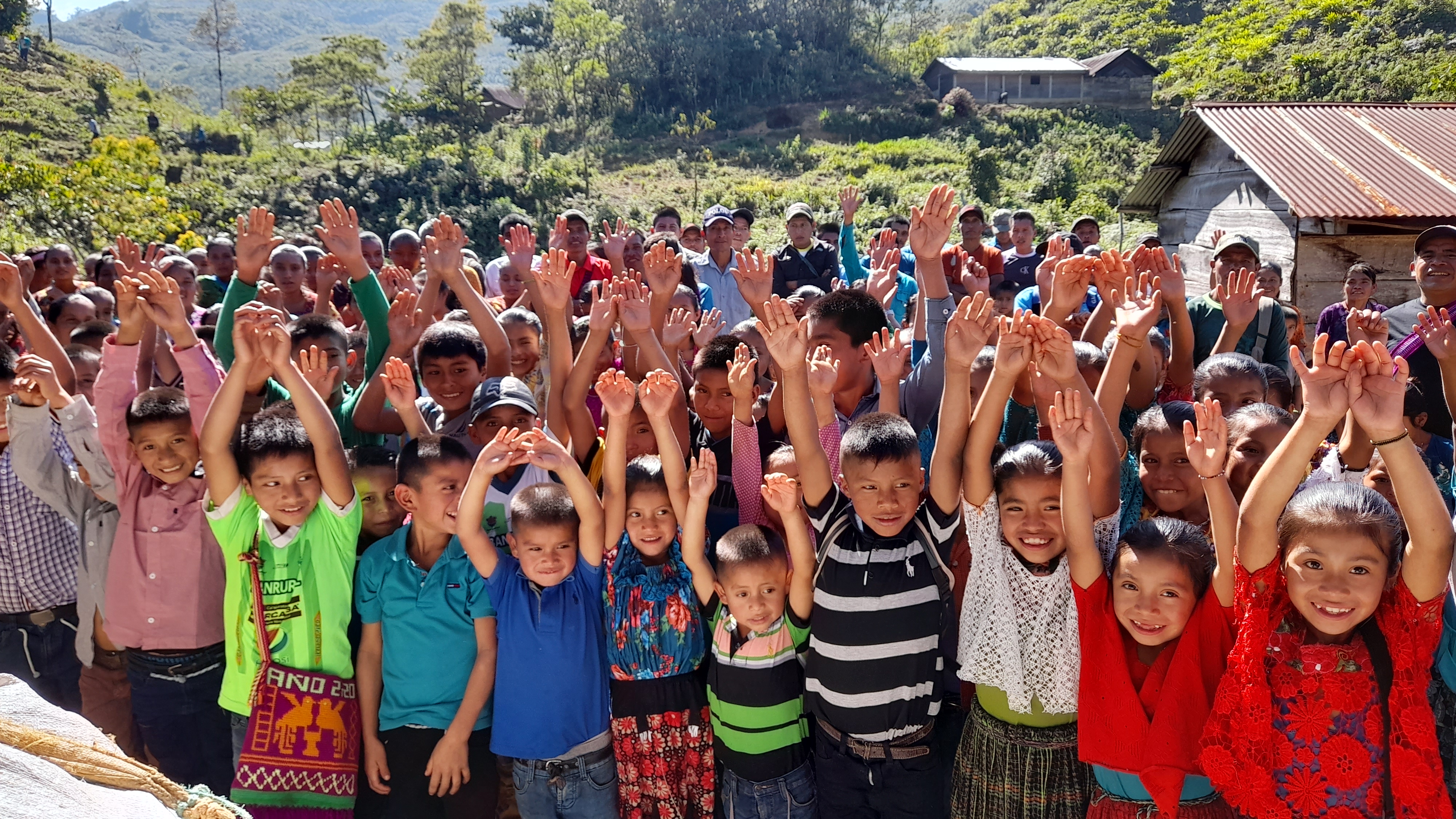 Niñas, niños y personas de una comunidad rural de Guatemala reunidos durante una actividad acompañada por ADICAY